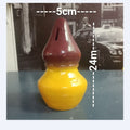 Yellow and red ceramic object with measurements on a blurred background